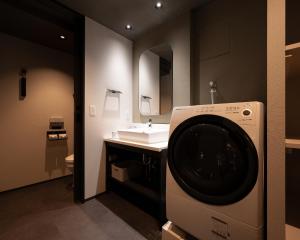 a bathroom with a washing machine and a sink at MIMARU SUITES KYOTO CENTRAL in Kyoto