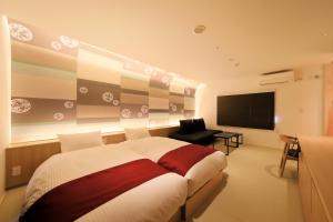 a bedroom with a large bed and a flat screen tv at Fuji Onsenji Yumedono in Fujikawaguchiko