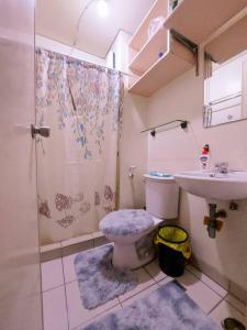 een badkamer met een douche, een toilet en een wastafel bij Affordable Cozy and Peaceful Loft Condo near Cubao in Manilla