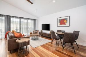 a living room with a couch and a table at Sheppard Art House Townhouse in Bright