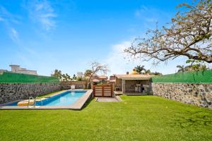 un patio trasero con piscina y pared de piedra en 3BR Casa familiar con alberca y asador en Oaxtepec, en Oaxtepec