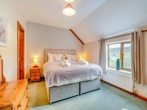 sypialnia z dużym łóżkiem i oknem w obiekcie Stable Cottage - Uk42936 w mieście Rosedale Abbey