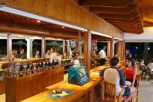 a group of people sitting at a bar at Nissiana Hotel & Bungalows in Ayia Napa