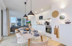 レンブルッフにあるNice Apartment In Lembruchdümmer Seeのテーブルと椅子のあるキッチンとリビングルーム