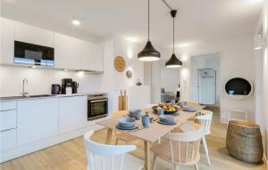 レンブルッフにあるNice Apartment In Lembruchdümmer Seeのテーブルと椅子のあるキッチンとダイニングルーム