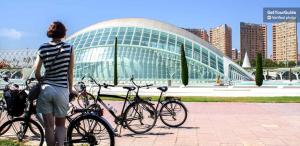 a man standing in front of a building with bikes at HOSTAL LETTO DAL MARE in Valencia