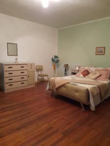 a bedroom with a bed and a dresser and a desk at Preciosa Casa Centrica y Acogedora in Tarija