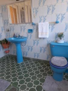 y baño con aseo azul y lavamanos. en Preciosa Casa Centrica y Acogedora, en Tarija