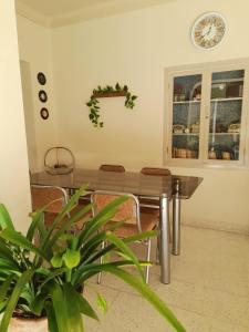 mesa de comedor con sillas y reloj en la pared en Preciosa Casa Centrica y Acogedora, en Tarija