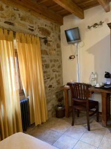 een kamer met een bureau, een stoel en een televisie bij Habitaciones Rurales La Vertedera I in Villar de Ciervo