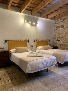 een kamer met 2 bedden in een gebouw bij Habitaciones Rurales La Vertedera I in Villar de Ciervo