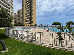 a swimming pool with chairs in front of some buildings at Depto piso 6 frente al mar in Antofagasta