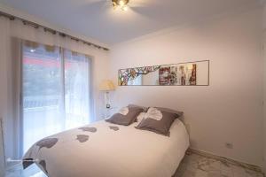 een slaapkamer met een groot bed en een raam bij Ô 27 Fleurie Cannes in Cannes