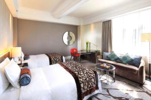 Habitación de hotel con 2 camas y sofá en Jin Jiang Hotel, en Shanghái