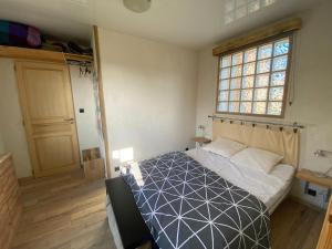 um quarto com uma cama e uma janela em Charming holiday home in a quiet location, near the coast, 2 bicycles em Donville-les-Bains