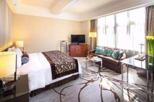 a hotel room with a bed and a couch at Jin Jiang Hotel in Shanghai