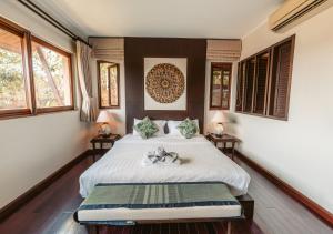 a bedroom with a bed and two tables with lamps at Tina Holiday Homes in Ko Chang