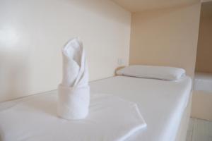 ein weißes Zimmer mit einem Bett und zwei Kissen in der Unterkunft FB Budgetel Suites in Cagayan de Oro