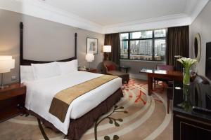 a hotel room with a large bed and a desk at Jin Jiang Hotel in Shanghai