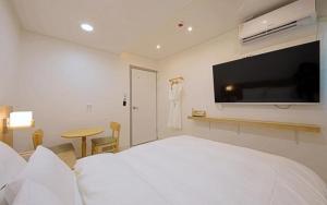 ein Hotelzimmer mit Bett und Flachbildfernseher in der Unterkunft Pier26 Hotel in Pohang