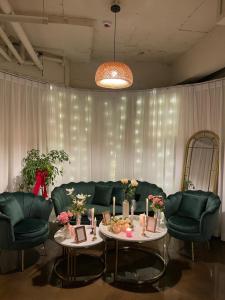 ein Wohnzimmer mit Sofa, Tischen und Stühlen in der Unterkunft Pier26 Hotel in Pohang