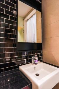 ein Badezimmer mit einem weißen Waschbecken und einem Spiegel in der Unterkunft Union Suites @ Sunway by Airhost in Petaling Jaya