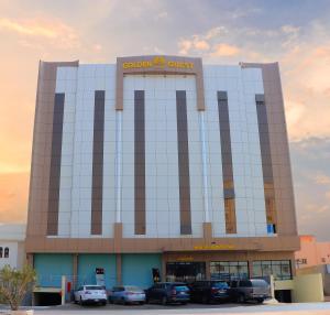 un bâtiment avec des voitures garées dans un parking dans l'établissement فندق النزيل الذهبي - Golden Guest Hotel, à Jazan