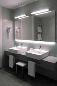 a bathroom with two sinks and a mirror at Hotel Lugano in Marghera