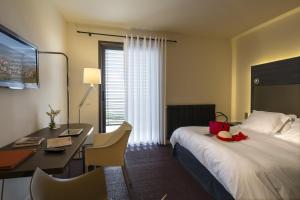 ein Hotelzimmer mit einem Bett und einem Schreibtisch mit einem Computer in der Unterkunft Hôtel Restaurant La Montagne De Brancion in Martailly-lès-Brancion + 74 Fotos