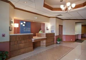 a woman standing at a reception desk in a hospital lobby at Holiday Inn Express- North Palm Beach and IHG Hotel in Juno Beach