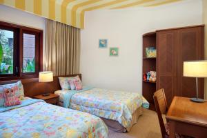 una camera con 2 letti, un tavolo e una scrivania di Holiday Inn Resort Batam, an IHG Hotel a Sekupang