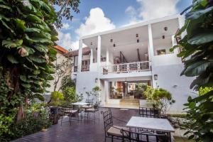 un patio con mesas y sillas frente a un edificio en Abian Biu Mansion en Canggu