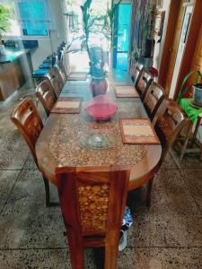 a long wooden table with chairs and a vase on it at Orchid Island B&B on the River with Pool & Jetty in Pacific Harbour