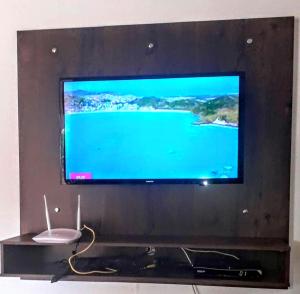 einen großen Flachbild-TV auf einem Entertainment-Center in der Unterkunft Rancho Espelho D'água in Capitólio