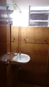 ein Bad mit einem Waschbecken und einem Fenster in der Unterkunft Rancho Espelho D'água in Capitólio