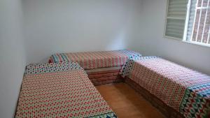 3 Betten in einem Zimmer mit Fenster in der Unterkunft Rancho Espelho D'água in Capitólio