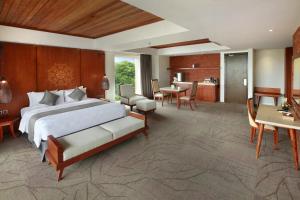 - une chambre avec un grand lit et une salle à manger dans l'établissement Jimbaran Bay Beach Resort and Spa by Prabhu, à Jimbaran