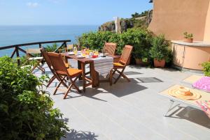 a patio with a table and chairs and the ocean at Villa Arborea in Sperlonga in Sperlonga