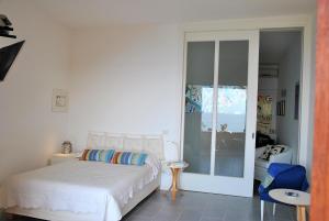 a bedroom with a bed and a sliding glass door at Villa Arborea in Sperlonga in Sperlonga +17 photos