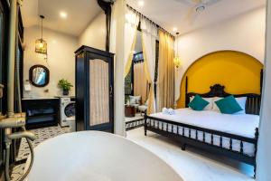 una camera da letto con un letto grande e un bagno di Hoi An Oasis Rosie Villa - 1 Bedroom with Private Pool and Garden View, Local Hoi An Decor a Hoi An