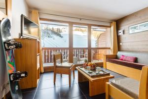 a living room with a couch and a table at Lagrange Vacances Les Chalets Edelweiss in La Plagne