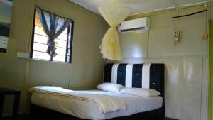 a bed in a room with a window at Long Beach Garden in Kampung Kuala Besut