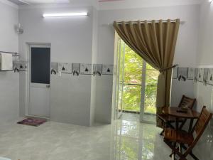 ein Bad mit einer Dusche, einem Tisch und einem Fenster in der Unterkunft Thien Ngoc Hostel in Cần Thơ