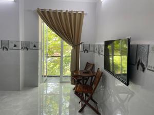 ein Esszimmer mit einem Tisch, Stühlen und einem Fenster in der Unterkunft Thien Ngoc Hostel in Cần Thơ