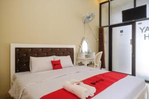 a bedroom with a large bed with red and white towels at RedDoorz Syariah near Alun Alun Wonosobo 3 in Wonosobo