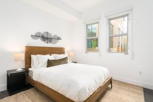 a white bedroom with a large bed and two windows at Mint House Menlo Park by Kasa in Menlo Park +27 photos
