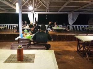 un gruppo di persone seduti ai tavoli in un ristorante di Long Beach Garden a Kampung Kuala Besut