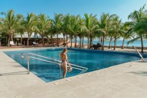 a woman walking into a swimming pool at a resort at Castillete in Cartagena de Indias
