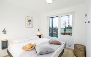 ein weißes Schlafzimmer mit einem Bett mit Hut darauf in der Unterkunft Nice Apartment In Lembruchdümmer See in Lembruch + 23 Fotos