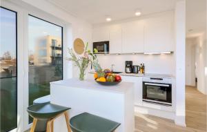 eine weiße Küche mit einer Schale Obst auf der Theke in der Unterkunft Nice Apartment In Lembruchdümmer See in Lembruch